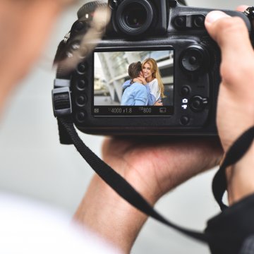 man looking at photo on dslr camera